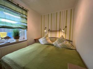 una camera con letto verde e finestra di FeWo Alt Bukow nahe Ostseebad Rerik ad Alt Bukow