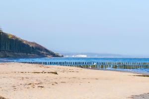 a sandy beach with a pier in the water at Finnhütte mit Kamin und Meerblick - Balkon in Nienhagen +19 photos