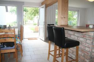 eine Küche mit einer Bar mit Stühlen und einem Tisch in der Unterkunft Landhaus am Bauernhof im Ostseeland in Boldenshagen