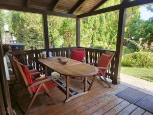 a wooden table and chairs on a wooden deck at RichiLak in Visegrád