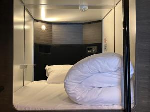Postel nebo postele na pokoji v ubytování Capsule Hotel Suzumoriya