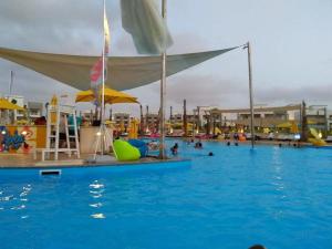 ein großes Schwimmbecken mit Menschen im Wasser in der Unterkunft VIP Chalet Amwaj North Cost E Zone The Terrace in El-Alamein