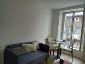 a living room with a couch and a table at Plat Gousset in Granville