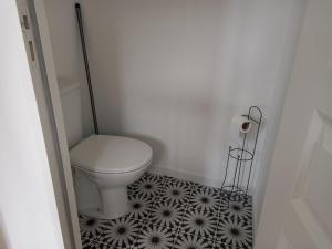 a bathroom with a toilet and a black and white tile floor at Plat Gousset in Granville