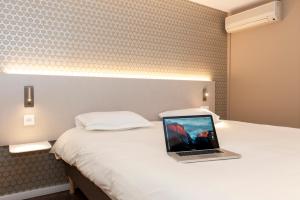 Letto o letti in una camera di Brit Hotel Avignon Sud Le Calendal
