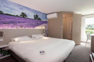 una camera da letto con un letto decorato con un murale di fiori viola di Brit Hotel Avignon Sud Le Calendal ad Avignone
