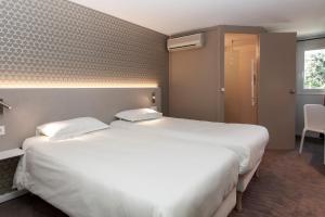 Letto o letti in una camera di Brit Hotel Avignon Sud Le Calendal