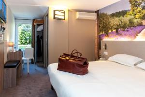 Letto o letti in una camera di Brit Hotel Avignon Sud Le Calendal