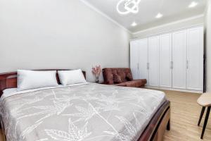 ein Schlafzimmer mit einem großen Bett und einer Couch in der Unterkunft Business Class Residential complex EXPO Boulevard in Astana