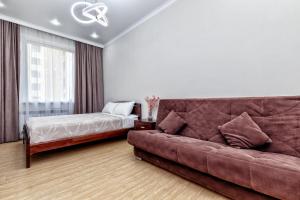 ein Wohnzimmer mit einer Couch und einem Bett in der Unterkunft Business Class Residential complex EXPO Boulevard in Astana
