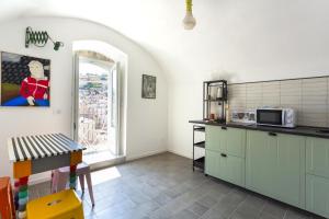 a kitchen with green cabinets and a window at ModicaFreakhouse in Modica