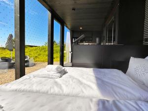 a large white bed in a room with large windows at Neugrad STYLE - 2er Cabins in Schleiden
