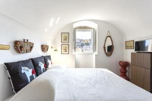 a bedroom with a white bed and a television at ModicaFreakhouse in Modica