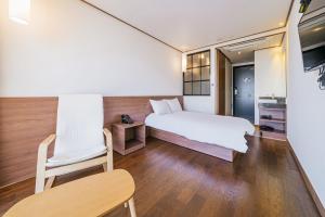 Postel nebo postele na pokoji v ubytování Tamara Jeju hotel