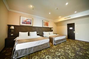 Ένα ή περισσότερα κρεβάτια σε δωμάτιο στο Imperial Palace Hotel Yerevan