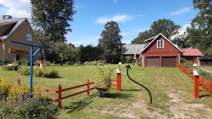 a yard with a red house and a barn at Lunden in Vittaryd