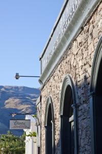 a stone building with a sign on the side of it at Olivers Central Otago in Clyde