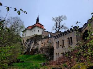a castle on top of a hill with a building at AP1, Hrubá Skála, Apartmány Nad Lípou in Hrubá Skála