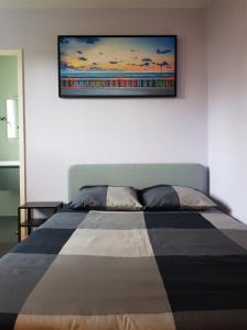 ein Schlafzimmer mit einem Bett mit einem Bild an der Wand in der Unterkunft Chambre Proche Astérix, Parc Expo Villepinte, CDG, Bourget in Saint-Witz
