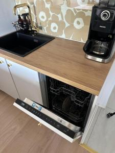 a microwave oven in a kitchen under a counter at Apartment Korkalonkatu in Rovaniemi
