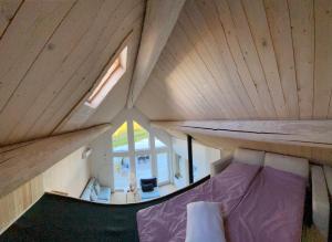 Cama pequeña en habitación con techo de madera en Dwa Słowa, en Giżycko