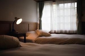 Postel nebo postele na pokoji v ubytování Hakuba Pension & Log Hotel Meteor