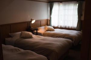 Postel nebo postele na pokoji v ubytování Hakuba Pension & Log Hotel Meteor