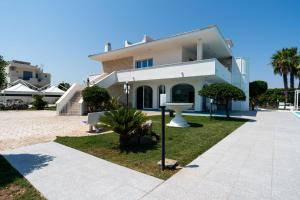 a large white house with a pathway in front of it at Villa Mar Mar con piscina by Wonderful Italy in Bari
