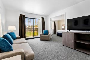 a hotel room with a couch and a bed and a television at Las Vegas Serene Hotel in Las Vegas