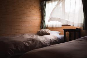Postel nebo postele na pokoji v ubytování Hakuba Pension & Log Hotel Meteor