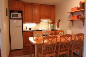 una cucina con tavolo, sedie e frigorifero di Levin Alppi 3 A 1 Apartment a Levi