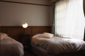 Postel nebo postele na pokoji v ubytování Hakuba Pension & Log Hotel Meteor