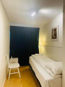 トロムソにあるArctic Inn, cozy single bed private room in a shared apartment with Stunning Tromso Viewsのベッドと椅子のある小さな寝室