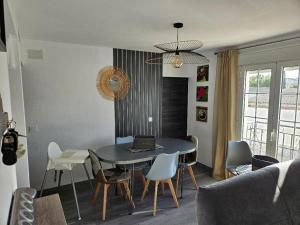 a dining room table with chairs and a laptop on it at Piso Ana appartement Cosy et moderne, Climatisé été, hiver in Campillos