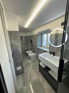 a bathroom with a sink and a toilet and a mirror at Residenza Rizzo Paestum in Paestum