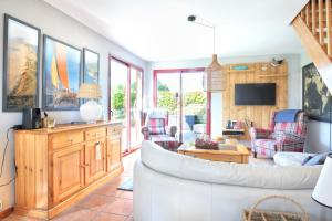 ein Wohnzimmer mit einem weißen Sofa und Stühlen in der Unterkunft La Maison Merlin - Maison avec piscine Sénoville in Senoville