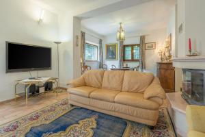 a living room with a couch and a fireplace at Santa Colomba House, Siena, Nature And Pool in Monteriggioni