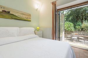 a bedroom with a bed and a large window at Santa Colomba House, Siena, Nature And Pool in Monteriggioni +19 photos