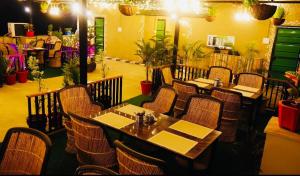 a dining room with tables and chairs in a restaurant at Hotel Hallmark in Alwar
