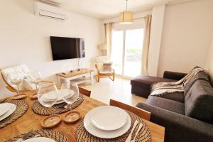 a living room with a table and a couch at Lovely Ground Floor 2 Bed with Golf Course Views in Sucina