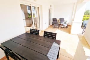 a table and chairs in a living room with a table at Lovely Ground Floor 2 Bed with Golf Course Views in Sucina
