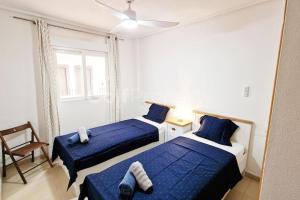 two beds in a white room with blue sheets at Lovely Ground Floor 2 Bed with Golf Course Views in Sucina +22 photos