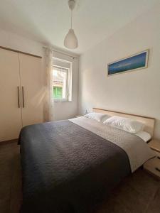 a bedroom with a large bed and a window at DreamWorksApartments-1 in Karlobag