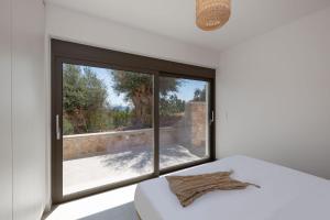 a bedroom with a window with a view of a patio at Villa Eptanisa in Sivota +30 photos