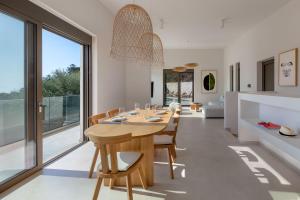 a dining room with a wooden table and chairs at Villa Eptanisa in Sivota