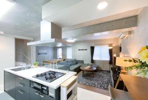 a kitchen and living room with a stove top oven at Uhome Otsuka Villa in Tokyo
