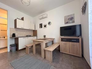 a living room with a table and a television at Flexibile Self Check-in ANYTIME in Karlobag