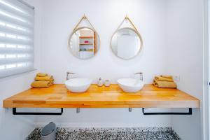 une salle de bain avec deux lavabos et deux miroirs dans l'établissement Casa Muk, à Calp