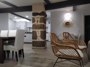 a dining room with white chairs and a table at Apartamento turístico Qué será, será in Cadalso
