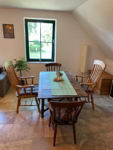 a dining room with a wooden table and chairs at Wohnung auf Gut Schnede in Vierhöfen